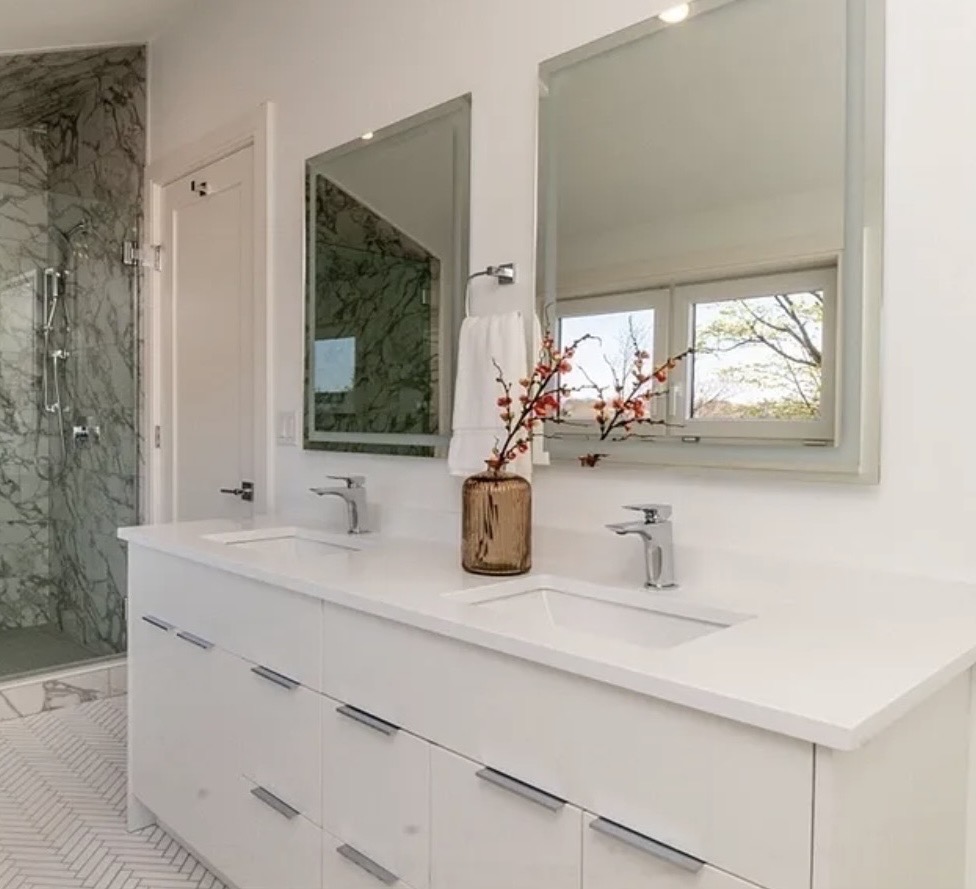 White cabinets and white countertop with a marble shower