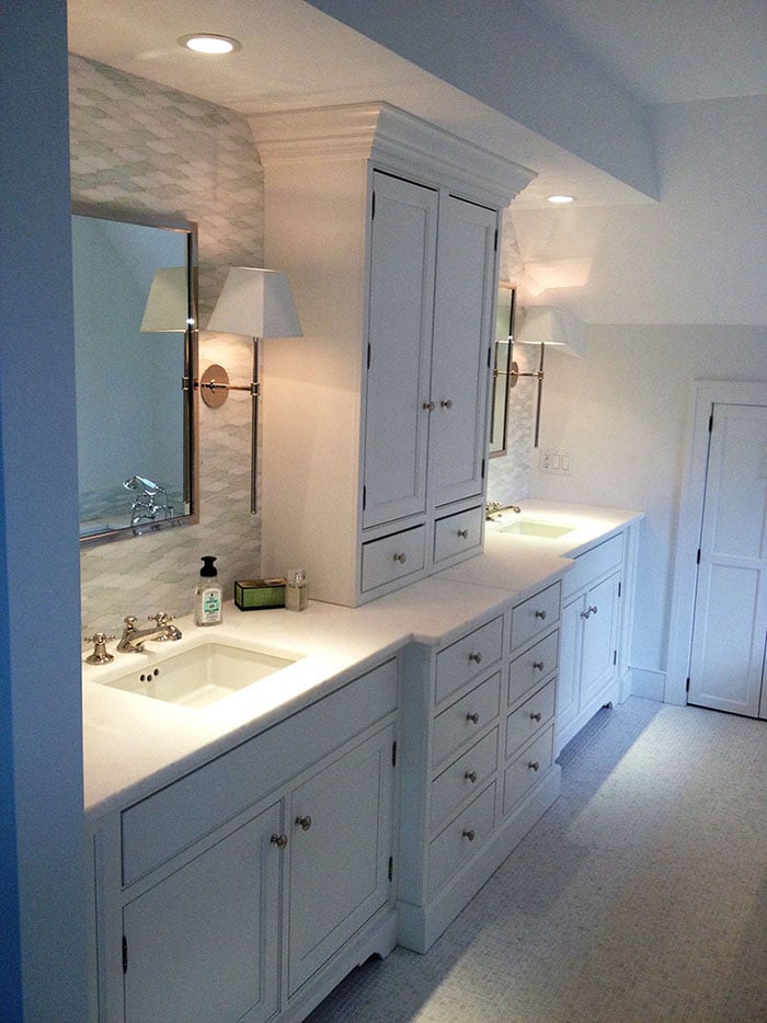 Grey tile wall with white cabinets and blue painted walls.