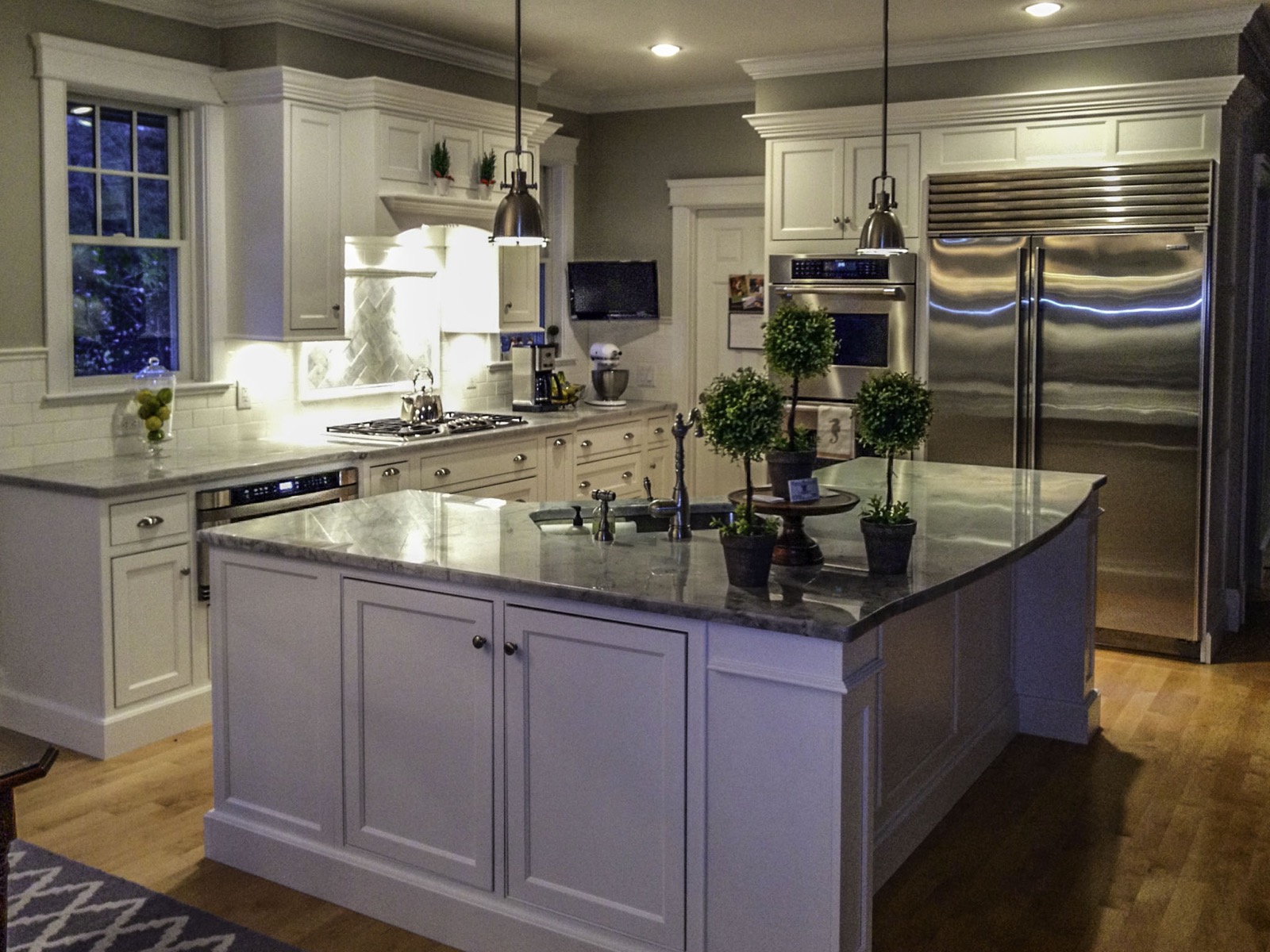 Hero gray kitchen with stainless steel appliances and pendant lights