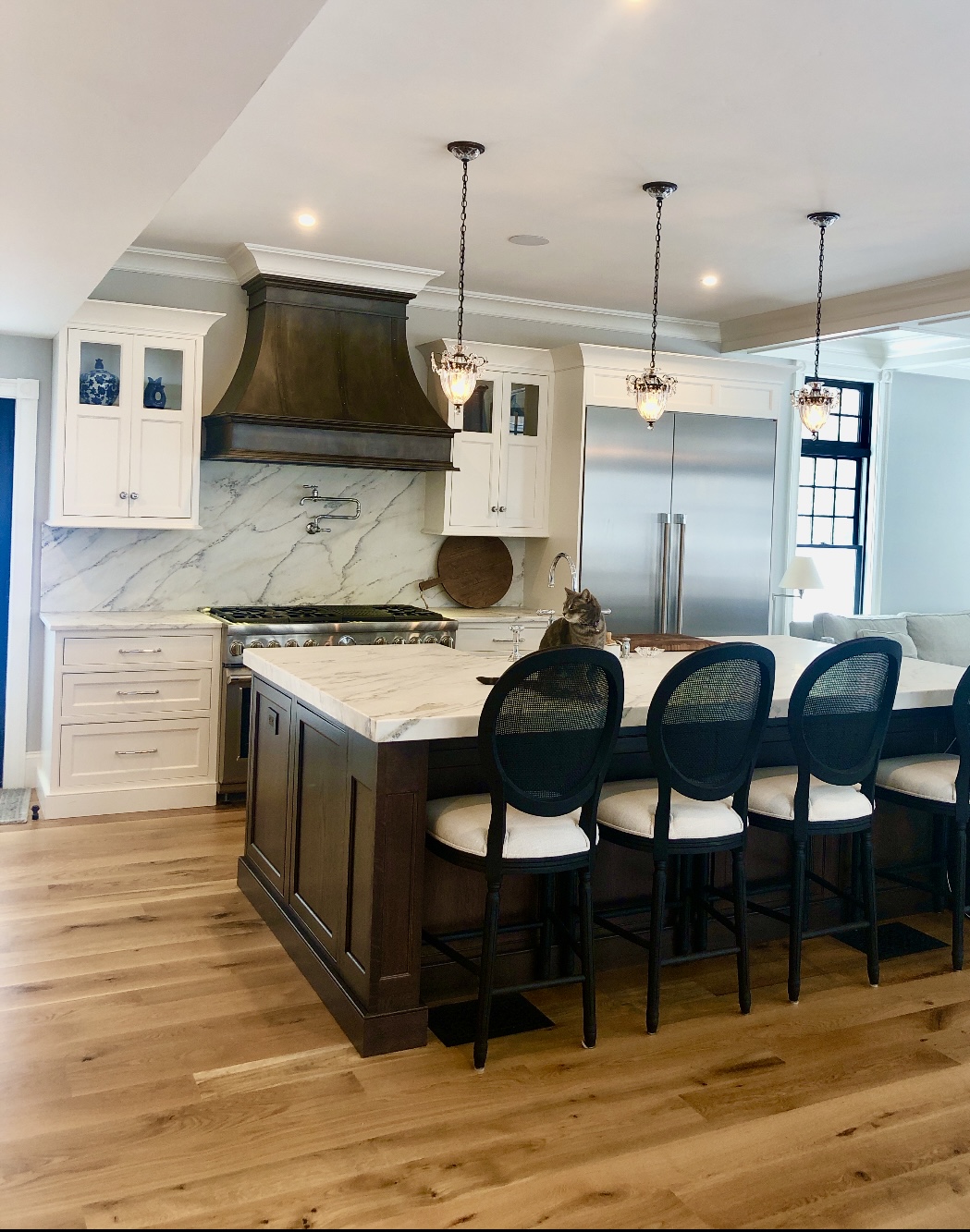 Kitchen with white marble island and backplash, and stainless steel appliances