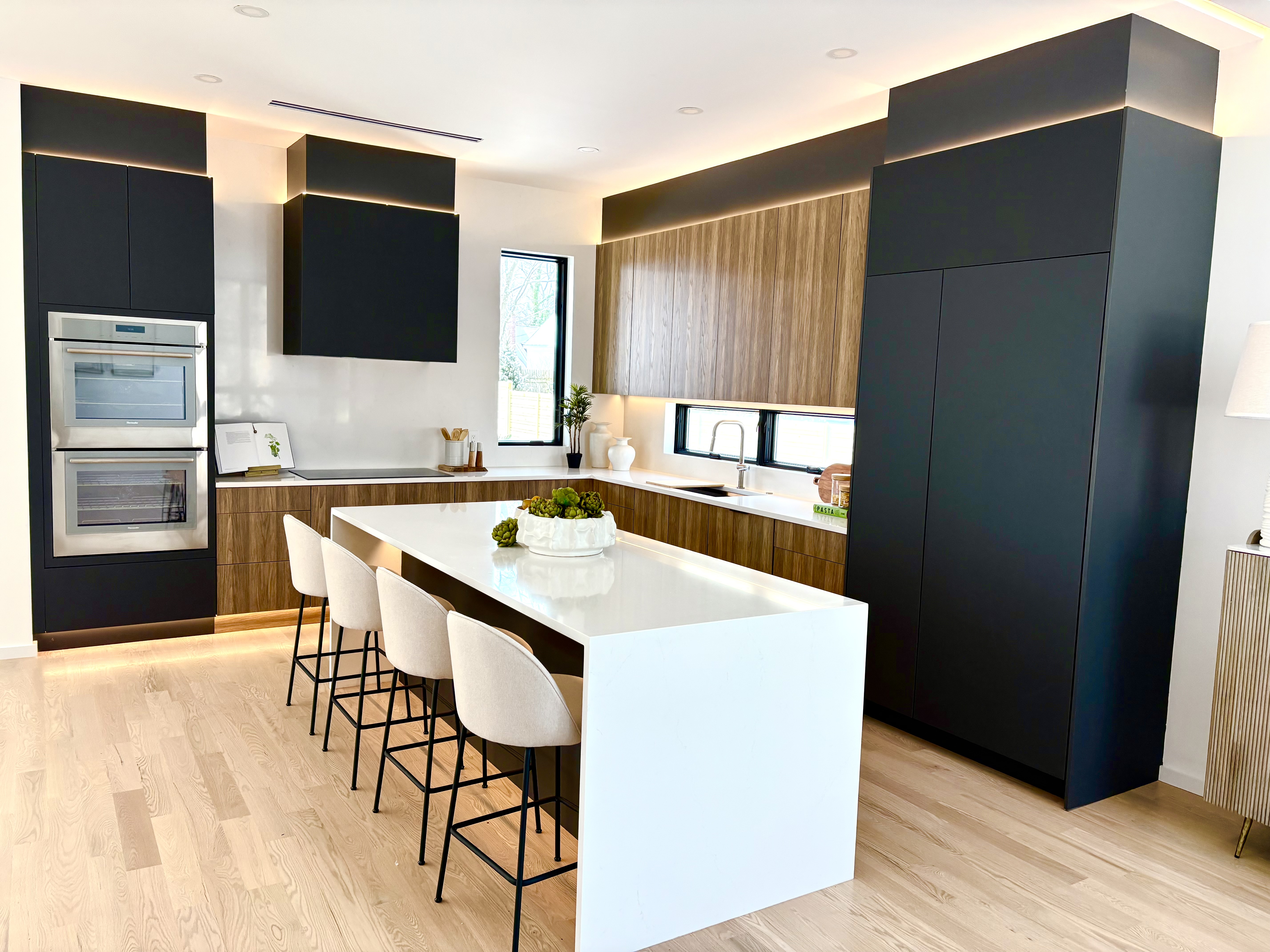 Kitchen with white table, wood cabinets and black appliances