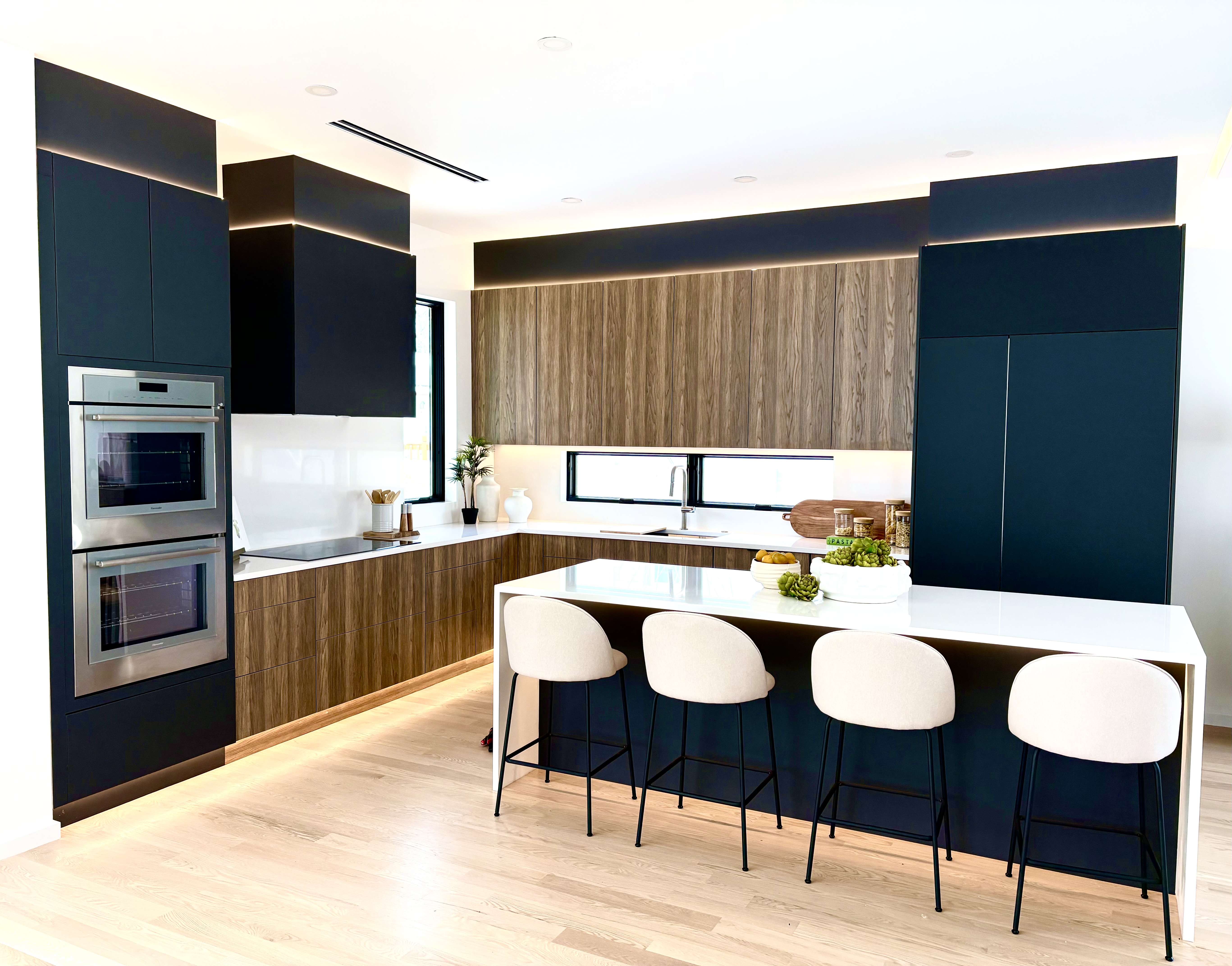 Kitchen with white table, wood cabinets and black appliances